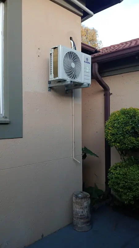 Alaska aircon outdoor unit installed on a wall bracket